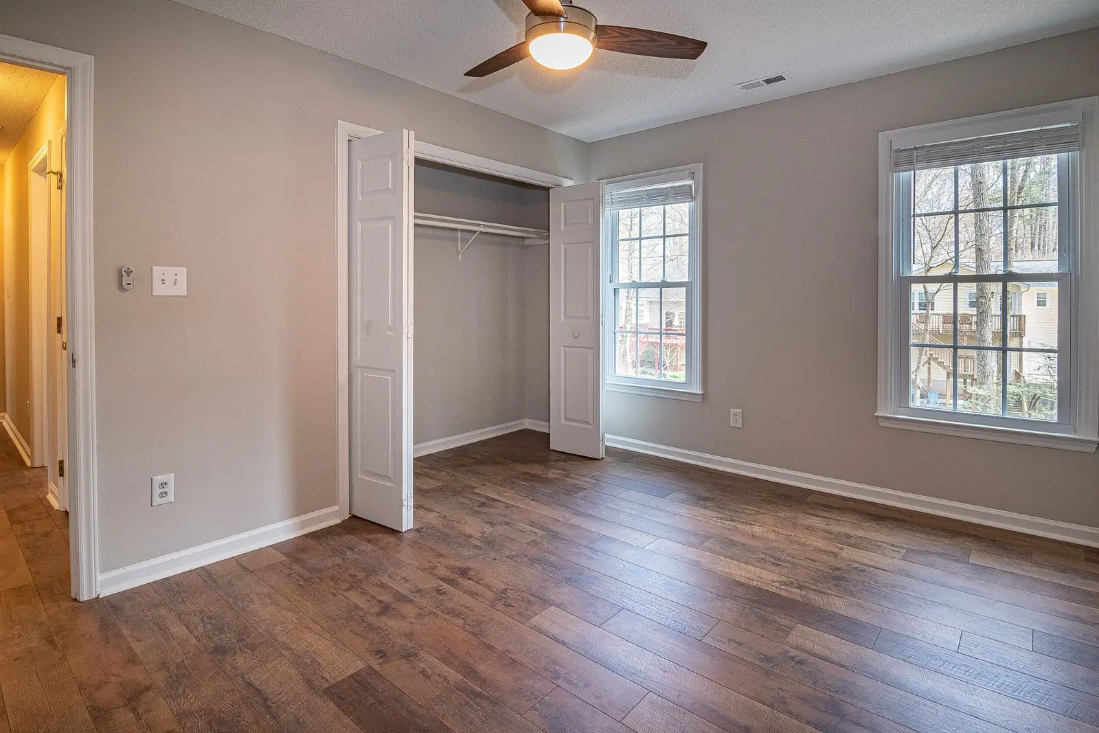 Empty bedroom with wood flooring and a ceiling fan