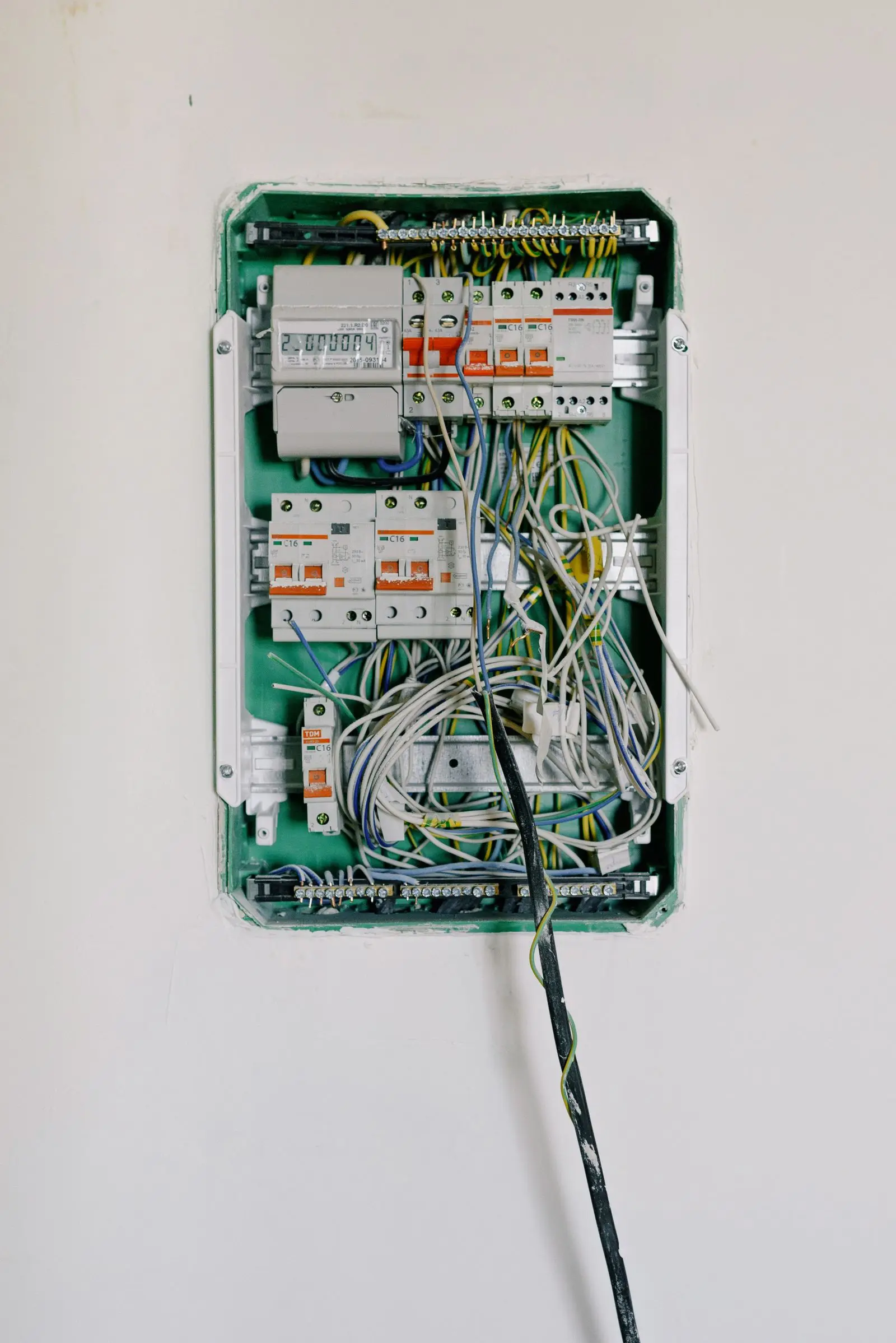 Open distribution box showing a few breakers and a tangle of small wires