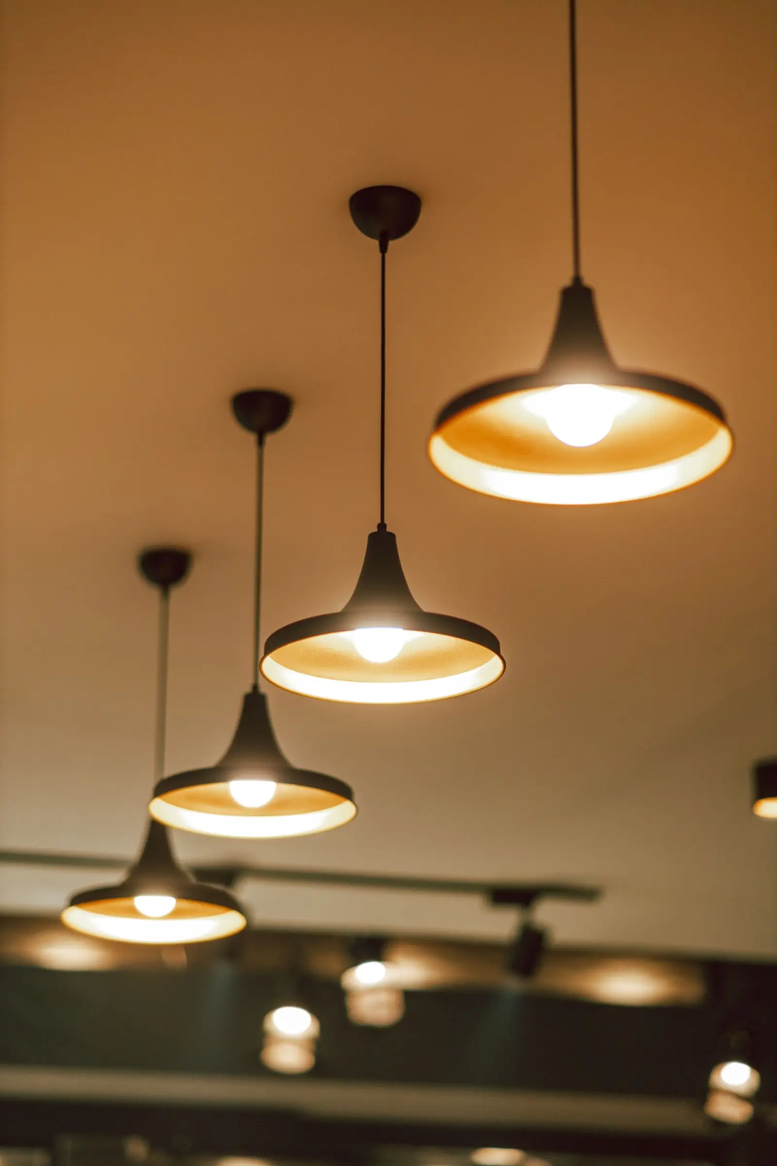 Three lit pendant lights hanging from a ceiling