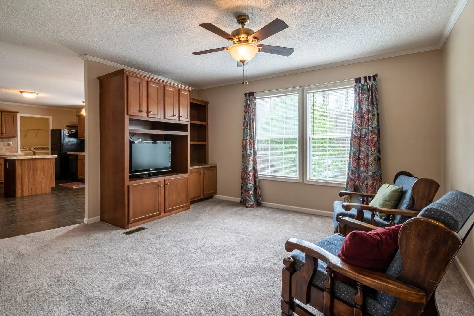 Living room with a ceiling fan with a light kit above the seating area