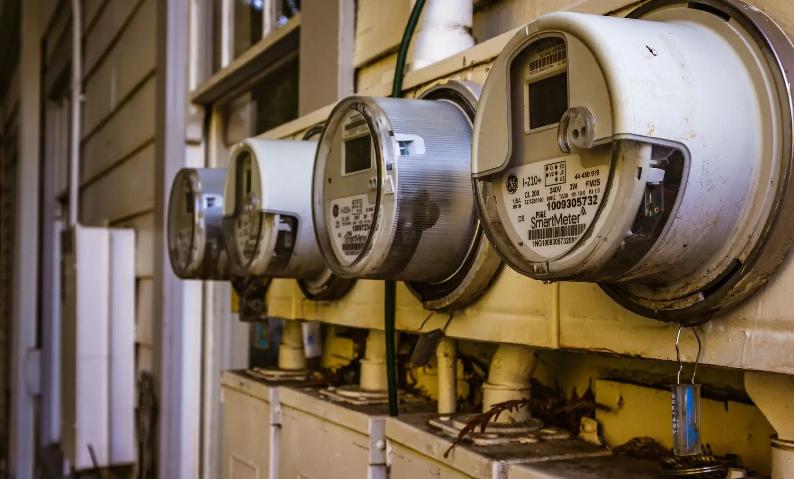 Row of round electric meters on the outside wall of a building