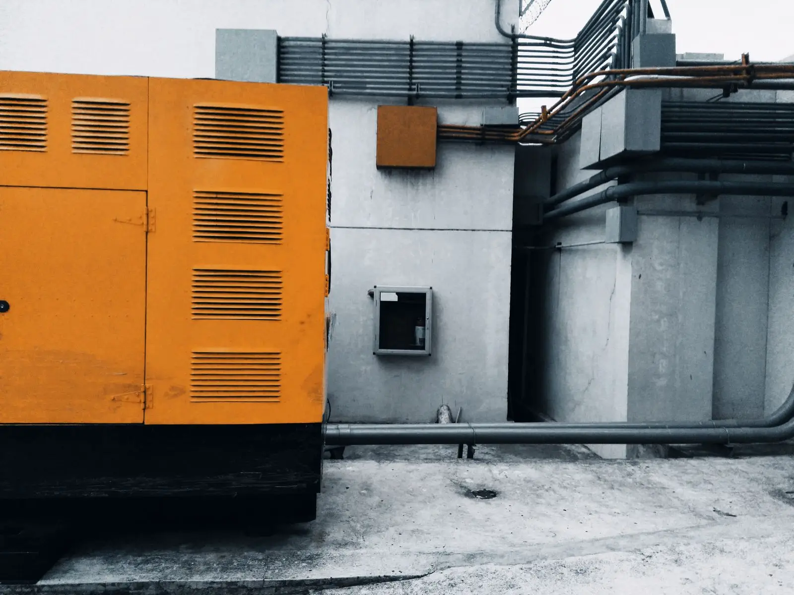 Large yellow generator enclosure standing outside a building