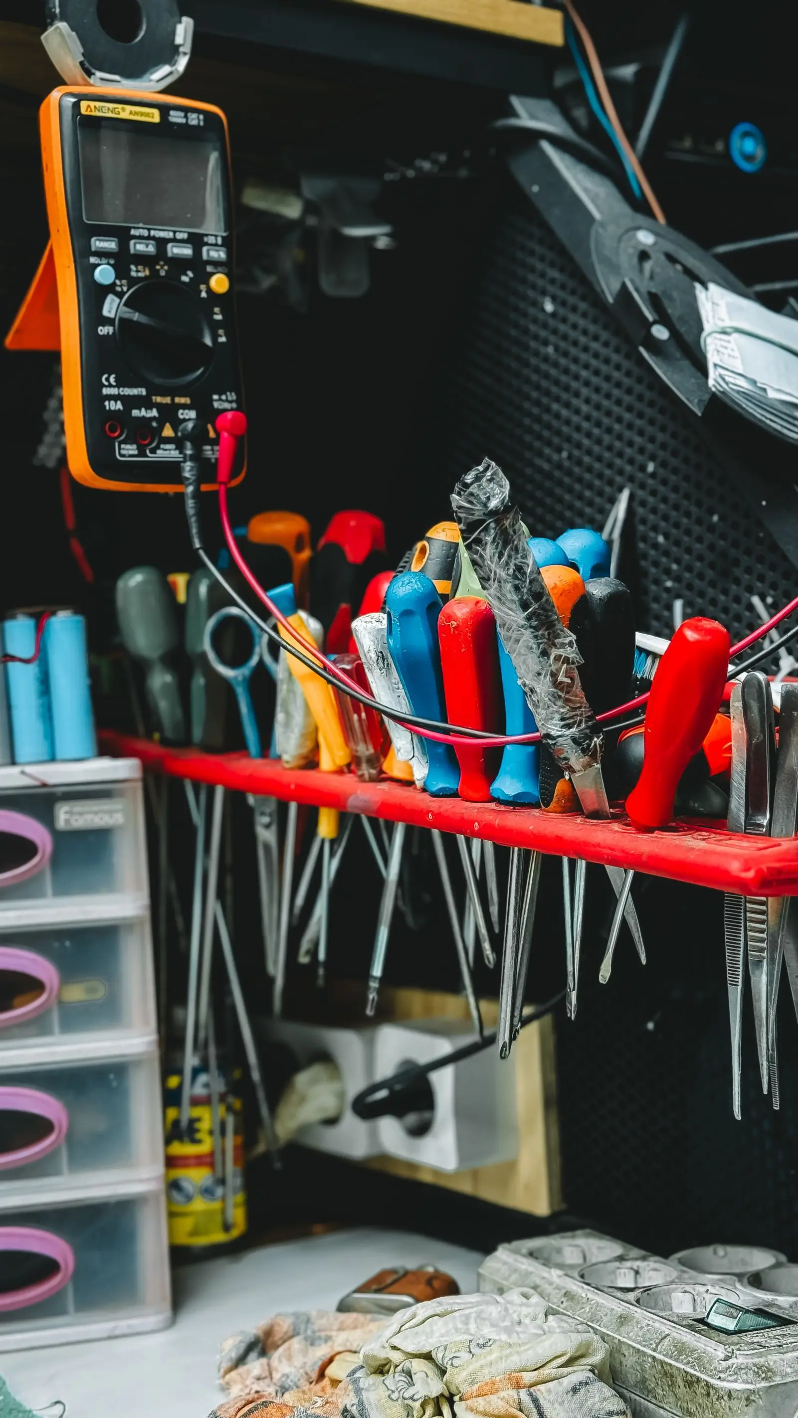 Rack of insulated screwdrivers and pliers above a workbench