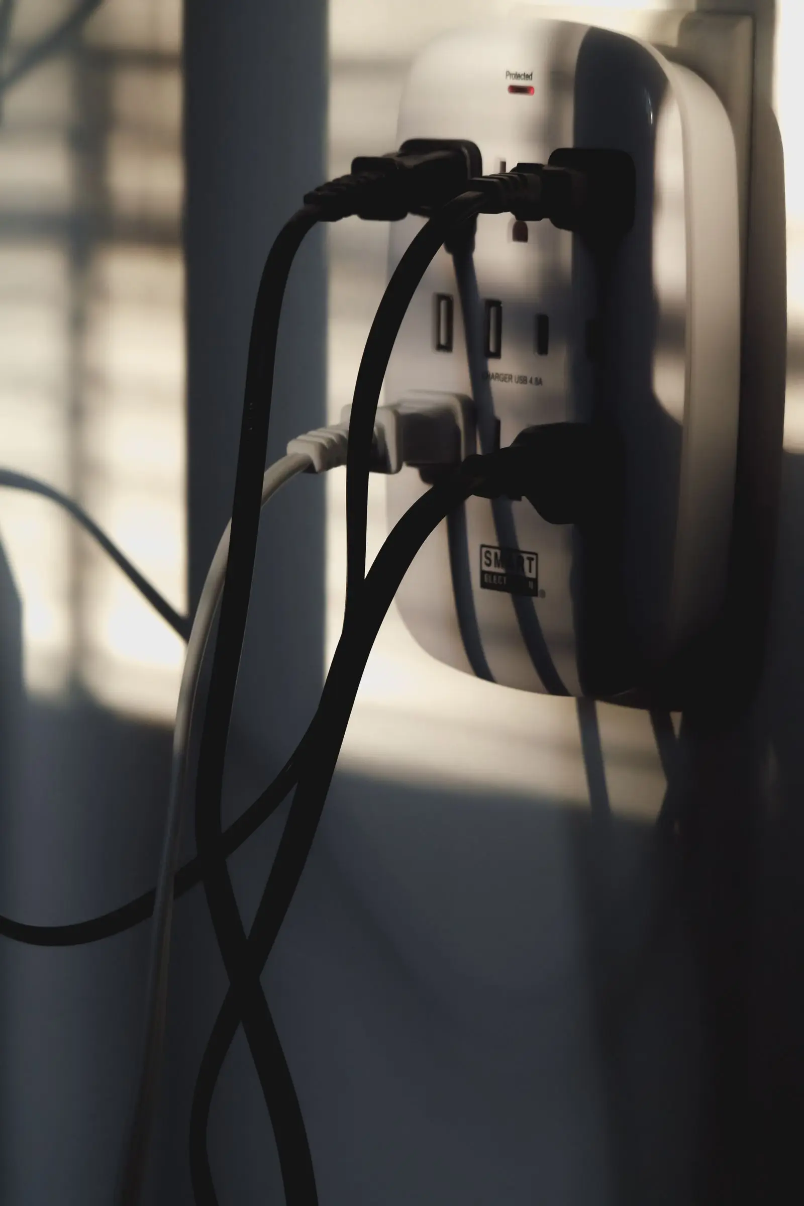 Several plugs and adapters crowded into one wall outlet