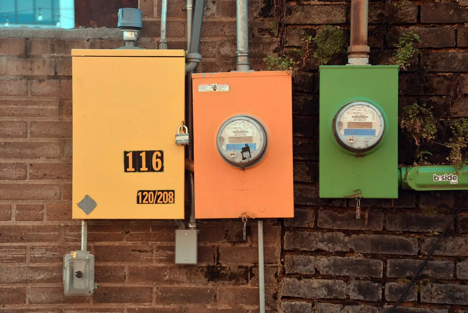 Brightly painted meter enclosures on a brick wall
