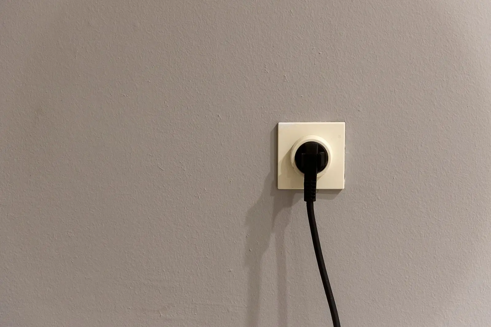 Black plug and cord in a single wall outlet