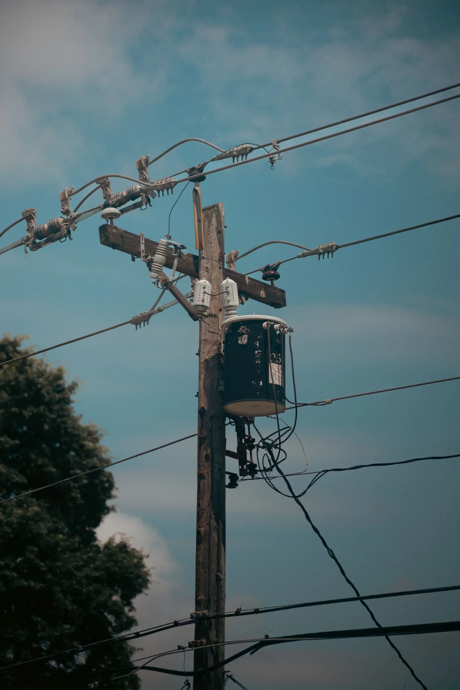Single transformer on a wooden utility pole with insulators above