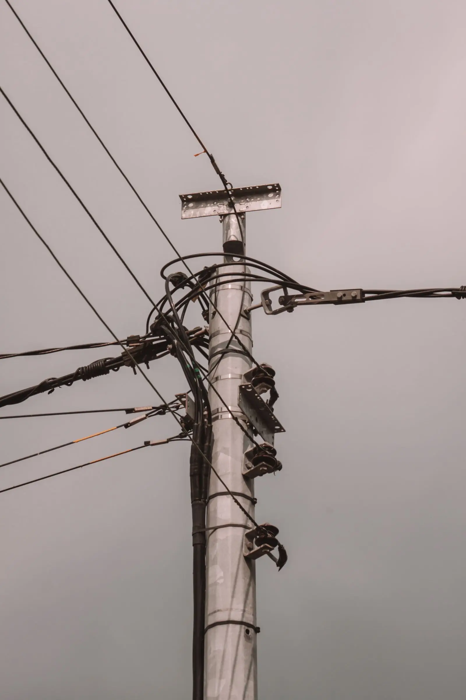 Utility pole carrying a transformer and many overhead wires